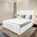 White upholstered bed in a modern bedroom setting with neutral walls and decor.